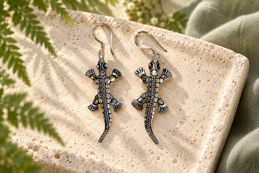 Silver lizard earrings on limestone with a botanical backdrop