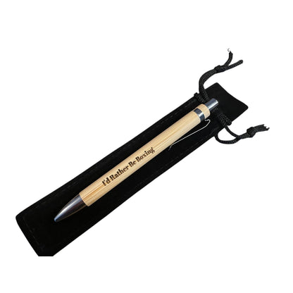 Pen with wooden barrel and silver clip in a black velvet pouch on a white background